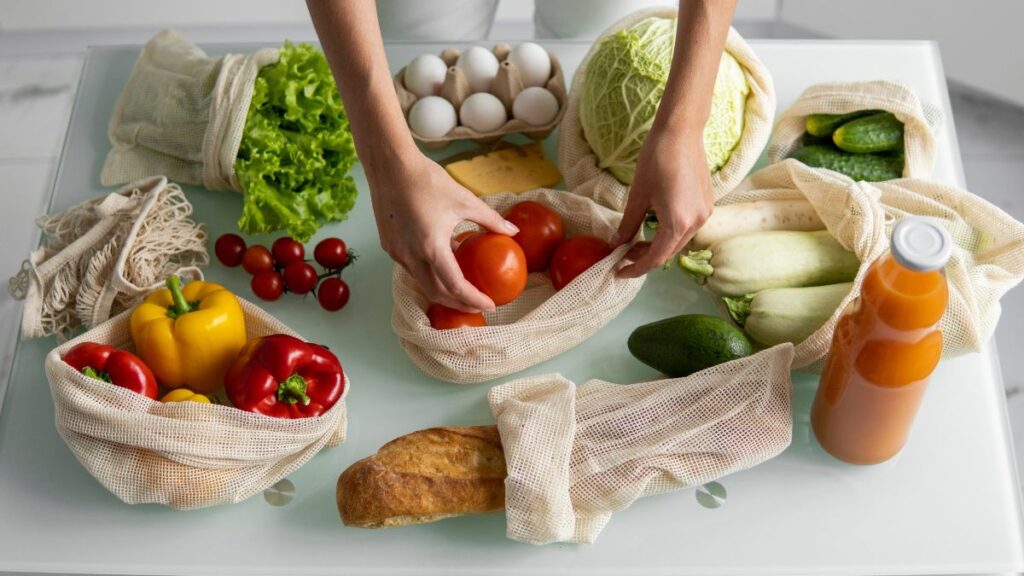 reusable grocery bags with produce in them on a counter 