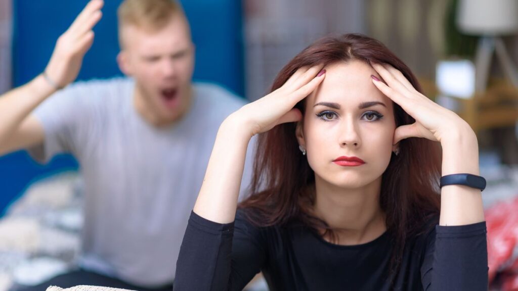 Man yelling and woman looking annoyed in front of him