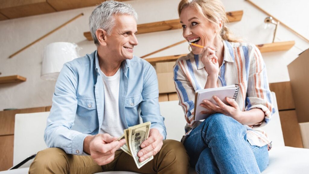 Older couple budgeting on the couch looking happy