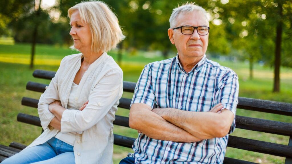 Older couple on a bench looking updset