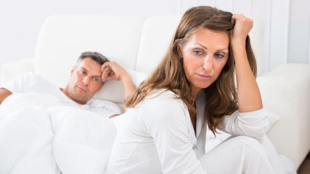 Unhappy middle aged couple woman sitting on the bed unhappy