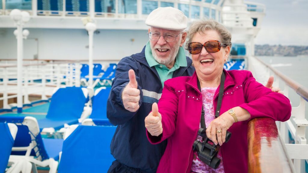 happy senior couple on a ship thumbs up