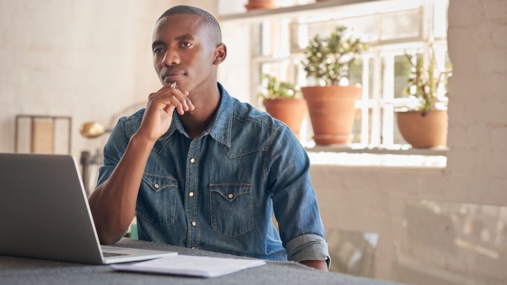 man thinking while sitting at his computer