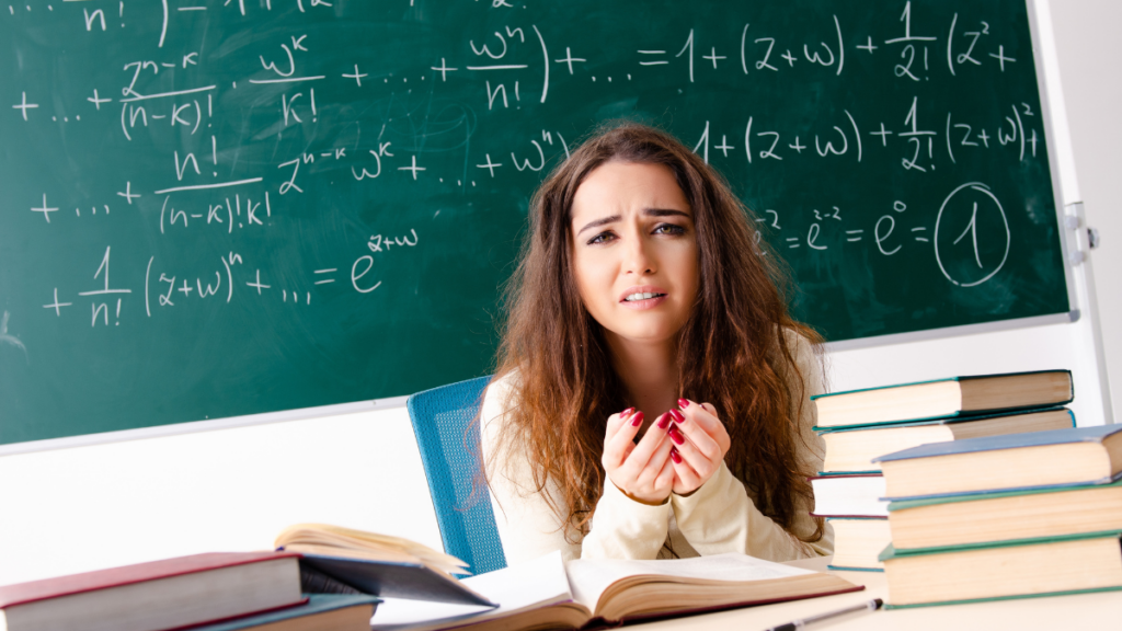 teacher sitting at her desk upset - math behind her on the board