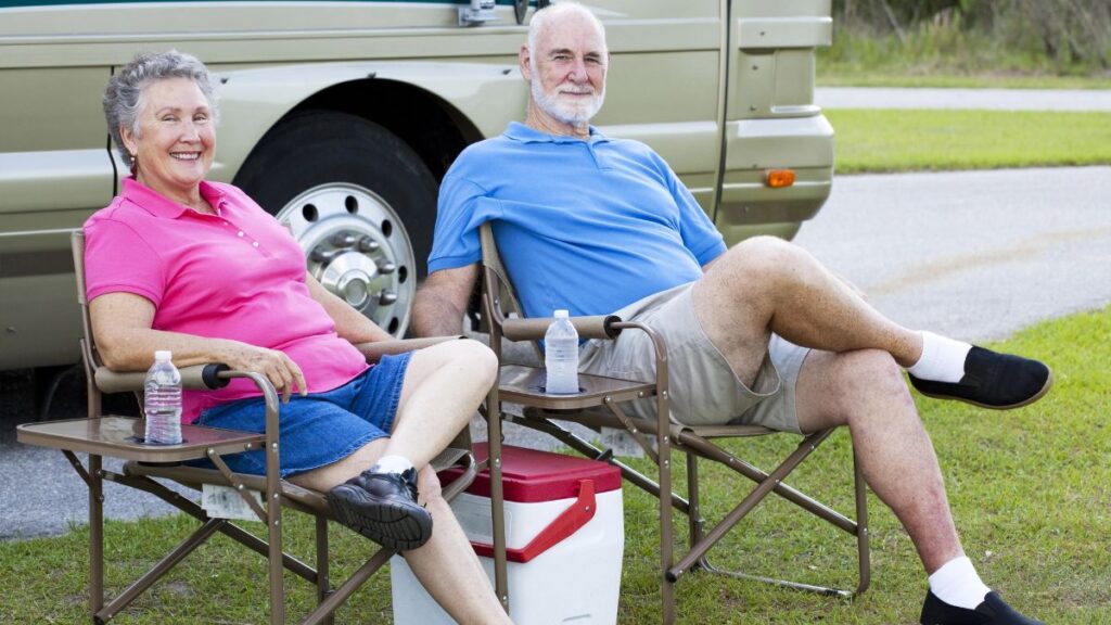 older couple sitting with their rv