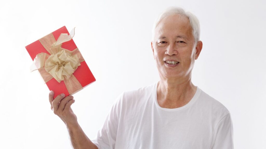 older man holding gift