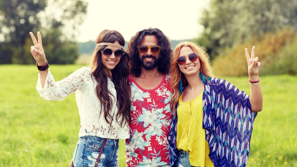 three people dressed like hippies doing a peace sign