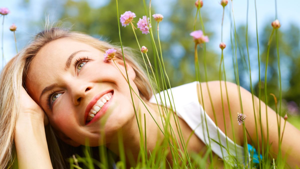 woman smiling laying in the grass