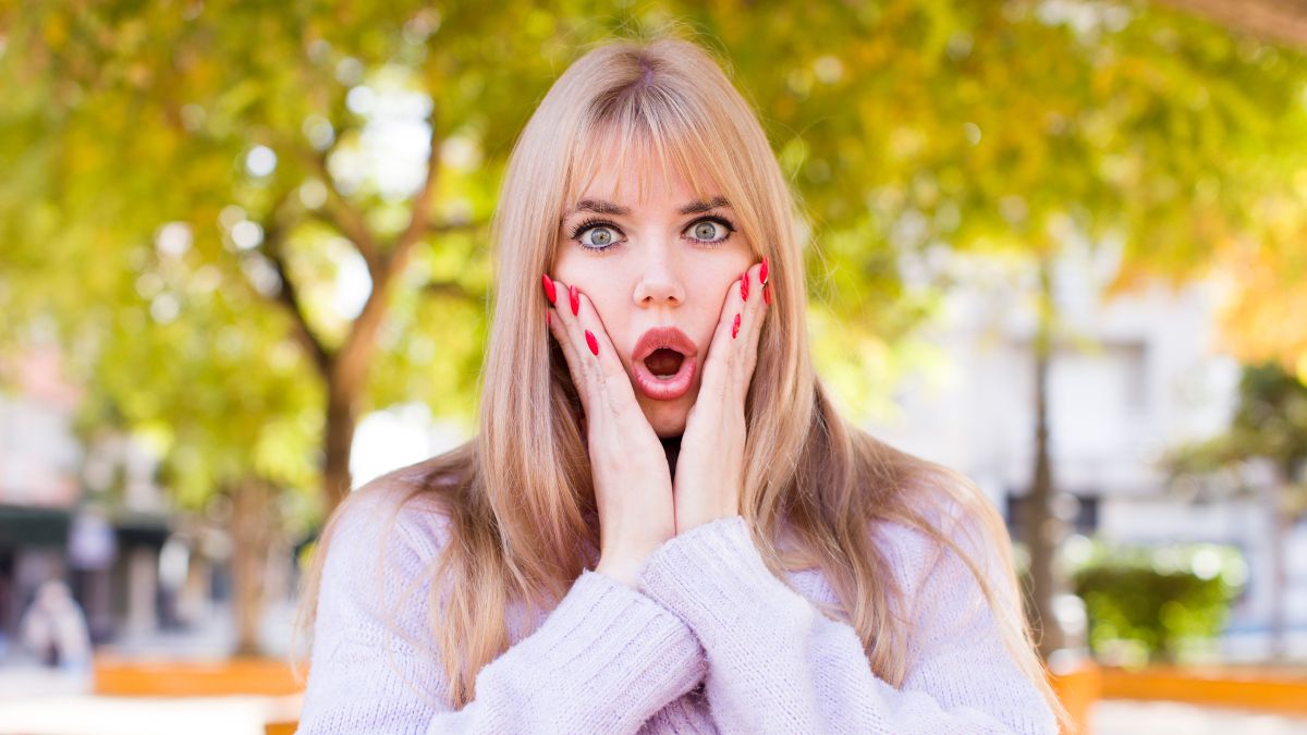 woman with hands on face looking surprised