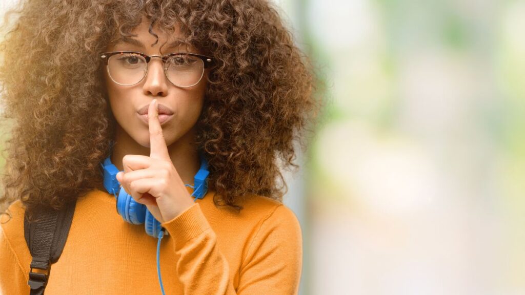 woman with her finger up showing shh