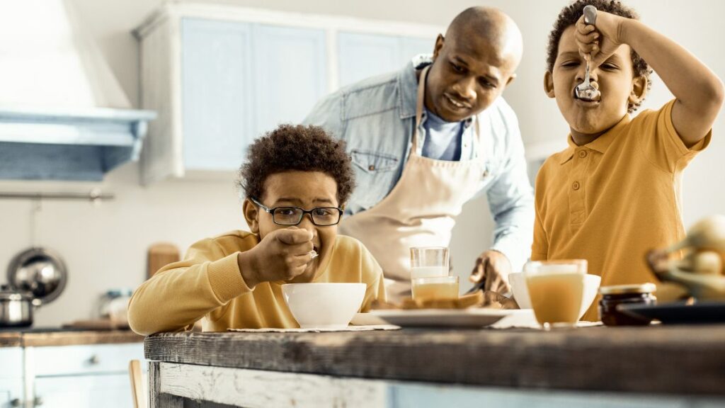 Man watching his kids eat a breakfast he made