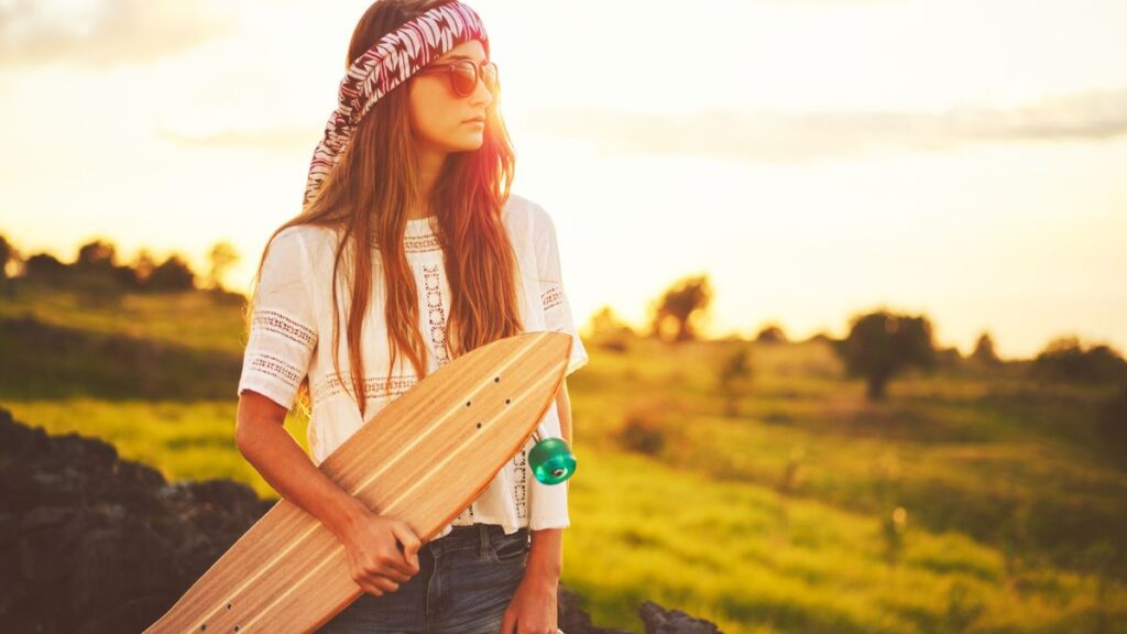 Young hipster woman holding a skateboard