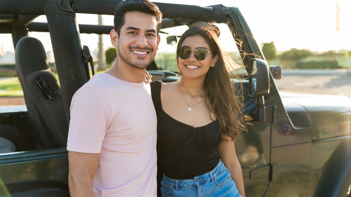 couple smiling by a jeep