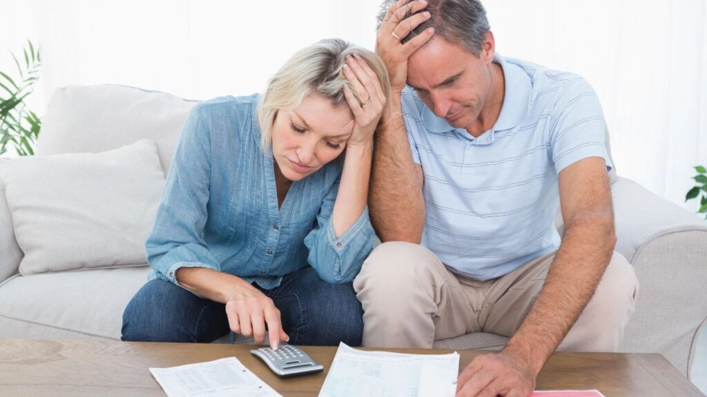 couple worried about money, looking at a bill