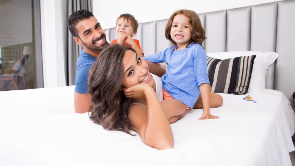 family on bed in hotel