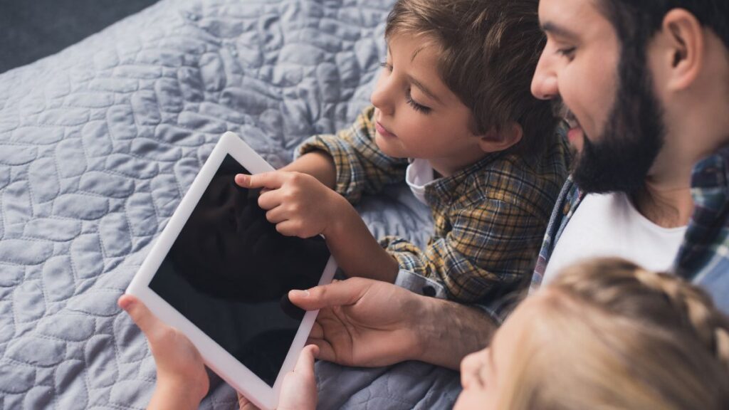 father and kids with tablet