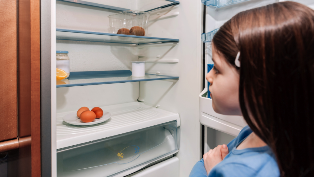 girl in front of empty fridge