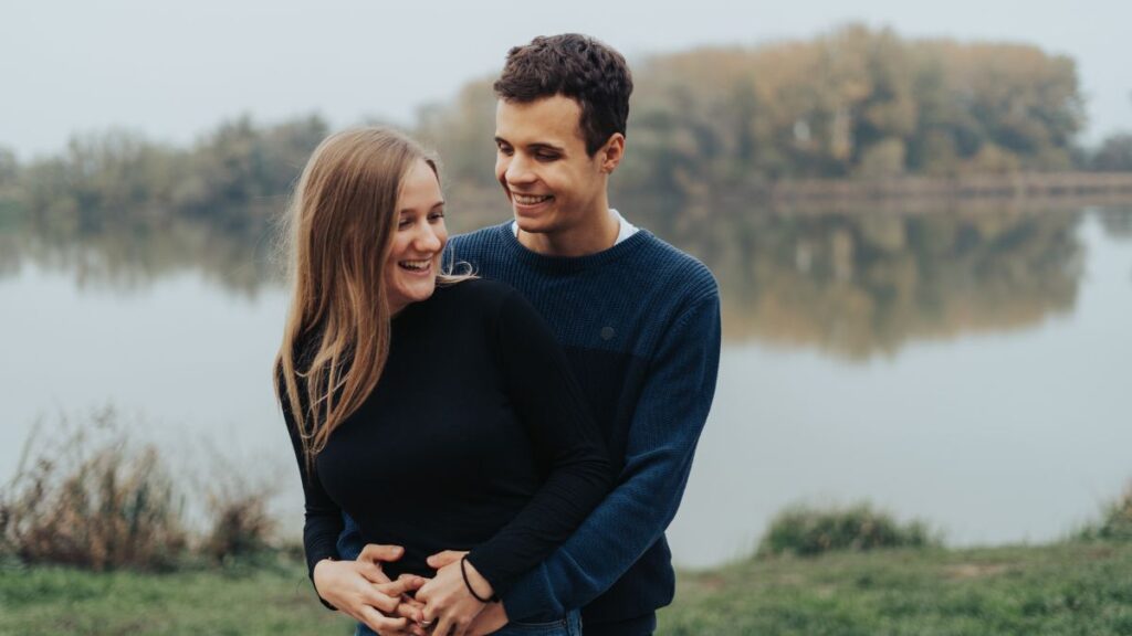 happy couple hugging by the water