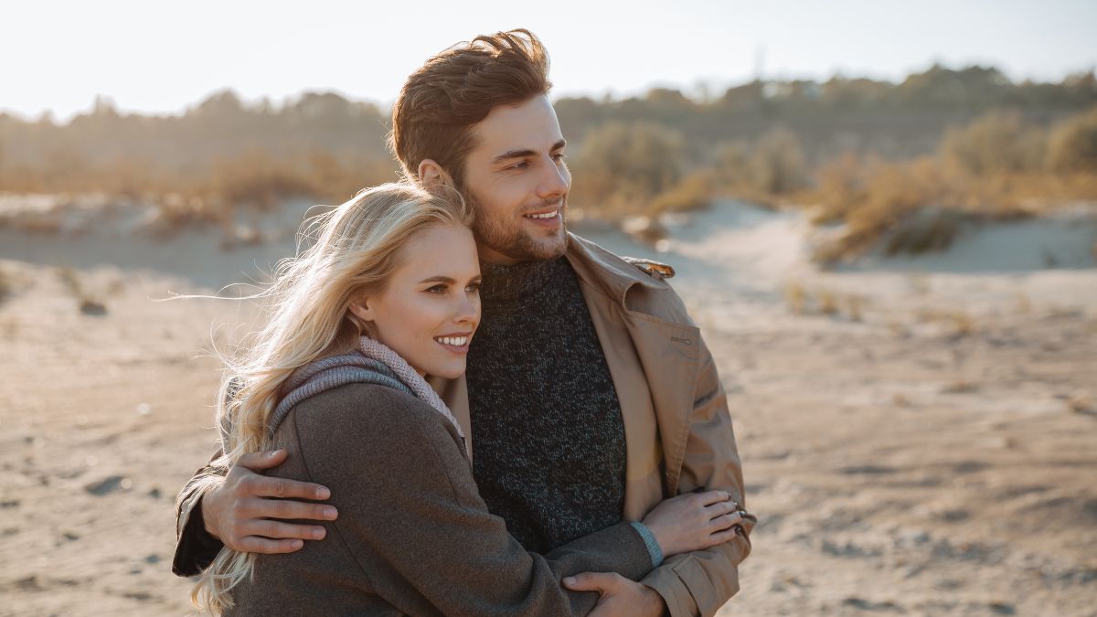 happy couple hugging on sand