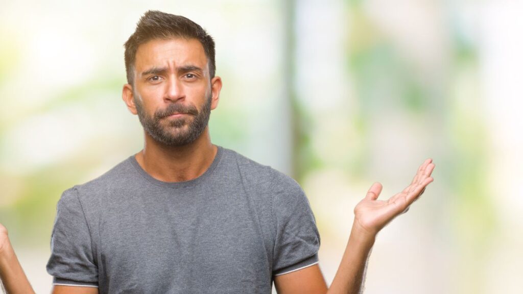 man looking confused with hands up