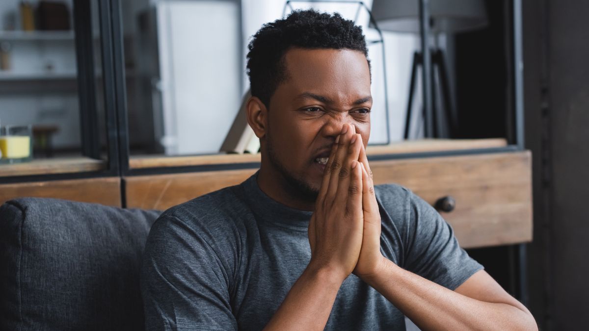 man looking stressed with hands by mouth