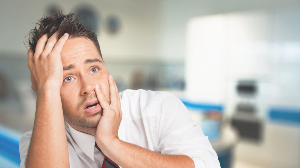 man looking stressed with hands on face