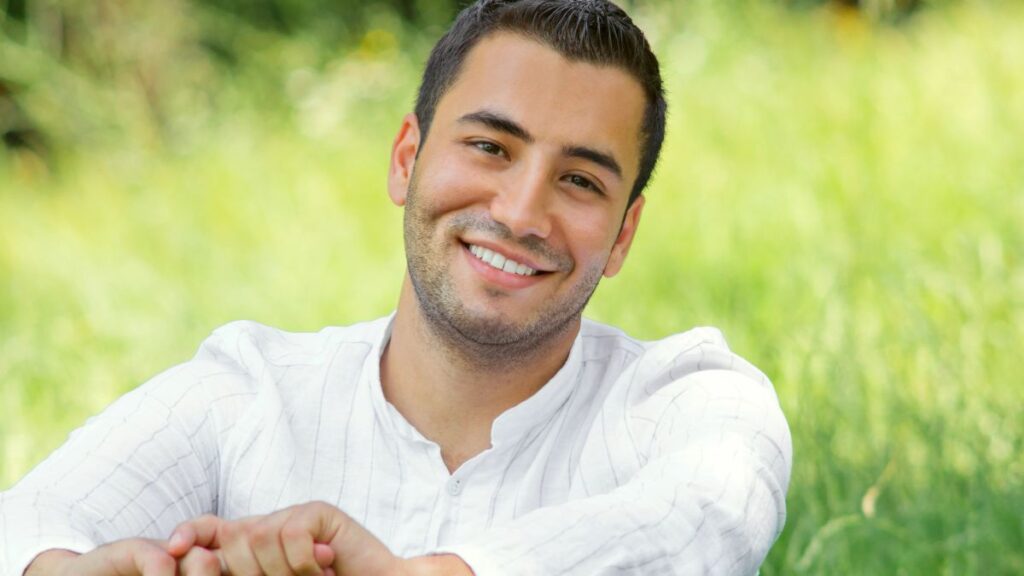 man smiling and sitting outside