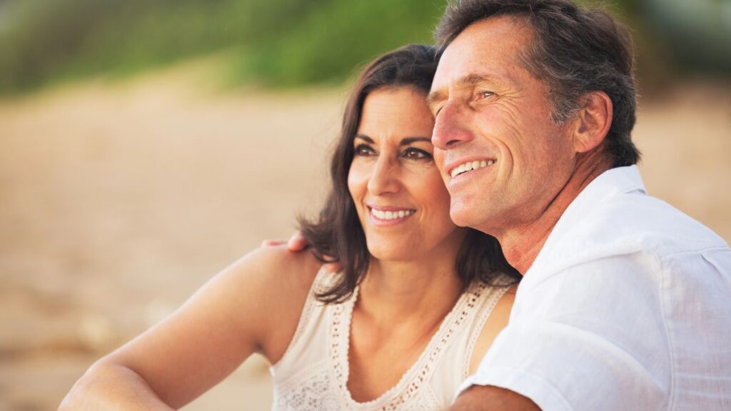 mature couple watching the sunset on the beach