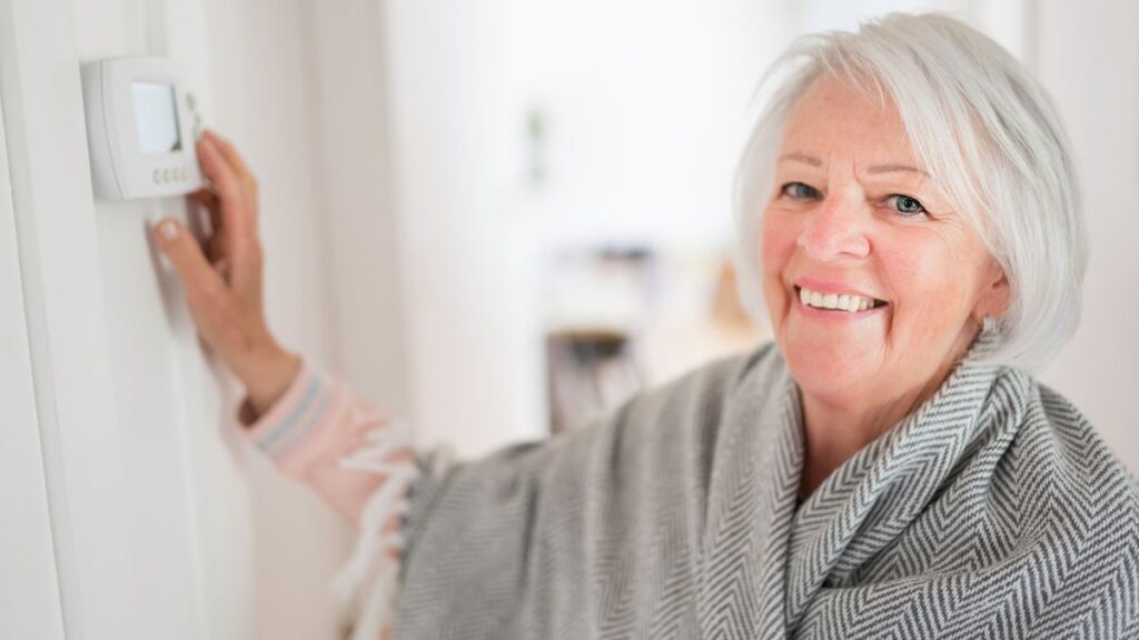 older woman changing thermostat