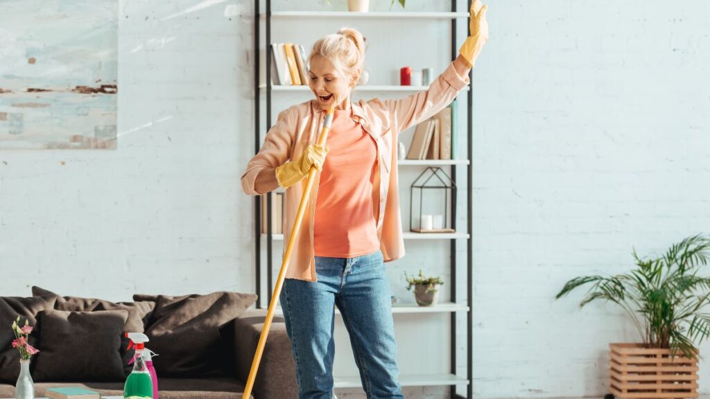 older woman cleaning and singing with her mop