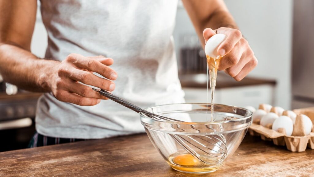 person cracking eggs