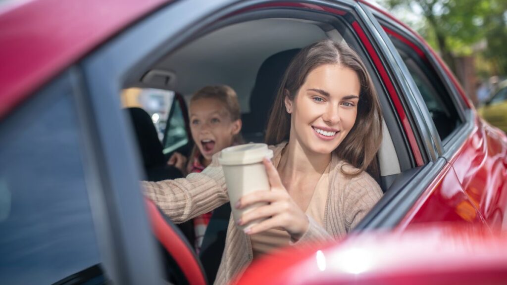 woman and girl in car with coffee