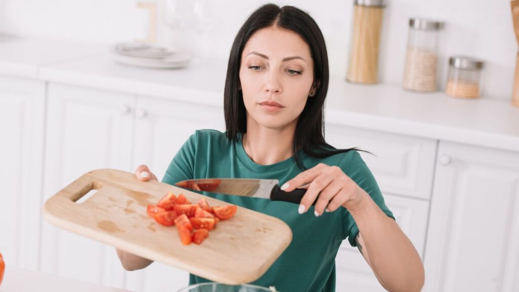 woman chopping up tomatoes