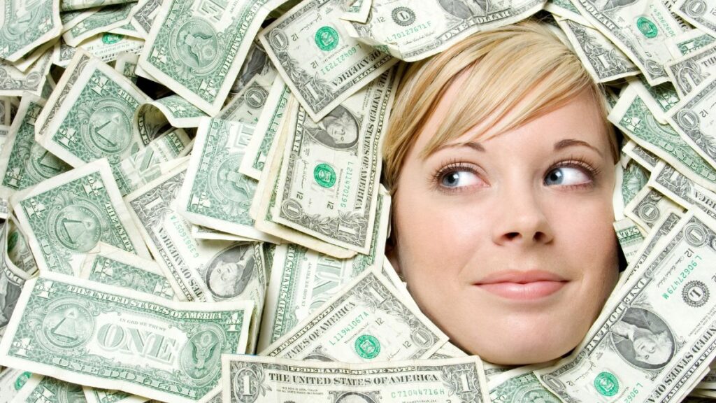 woman covered in money smiling