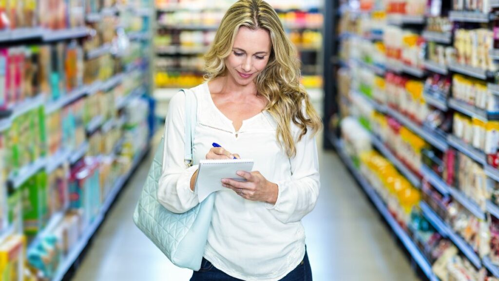 woman grocery shopping checking off a list