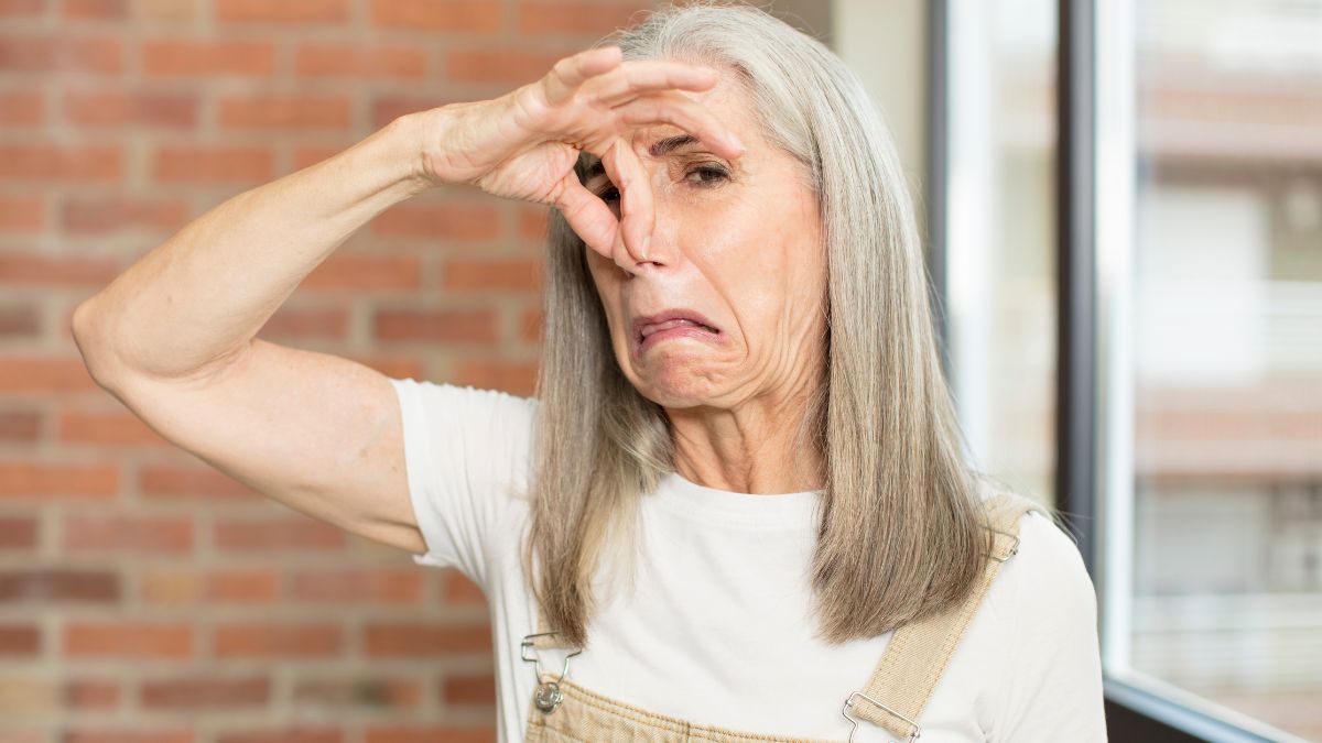 woman holding nose making disgusted face