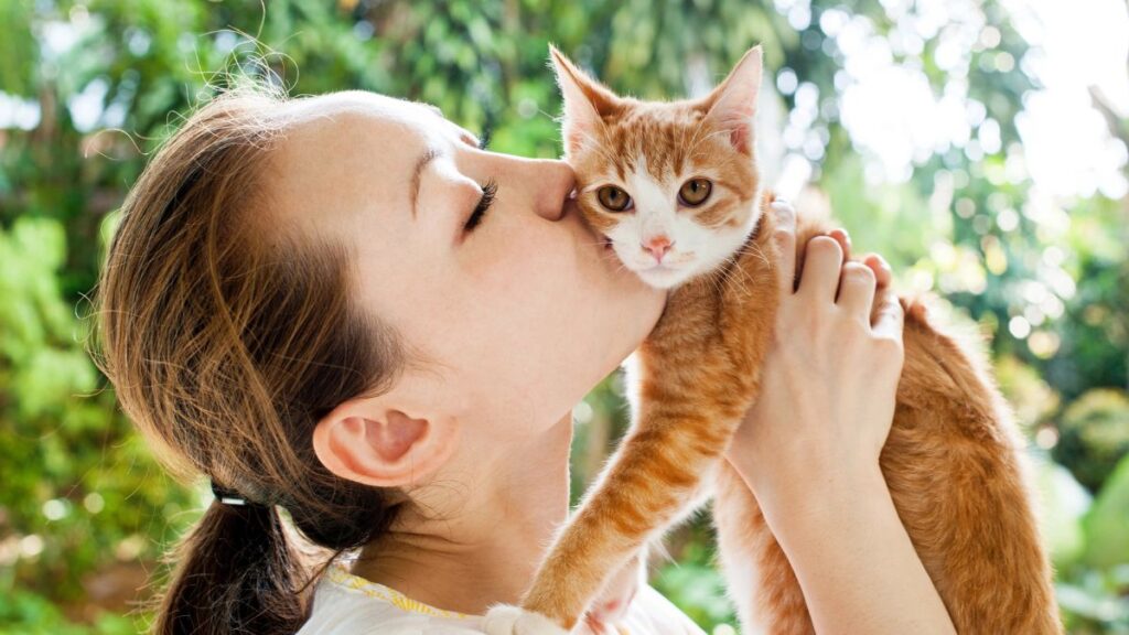 woman kissing a cat