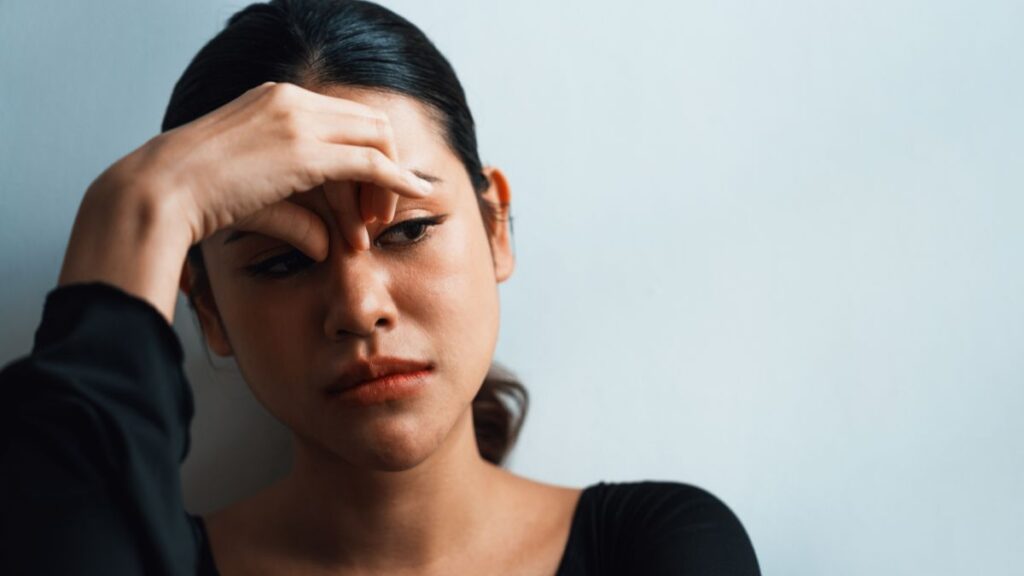 woman look sad holding the top of her nose