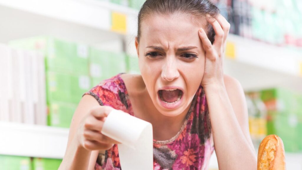 woman looking at a grocery bill crying