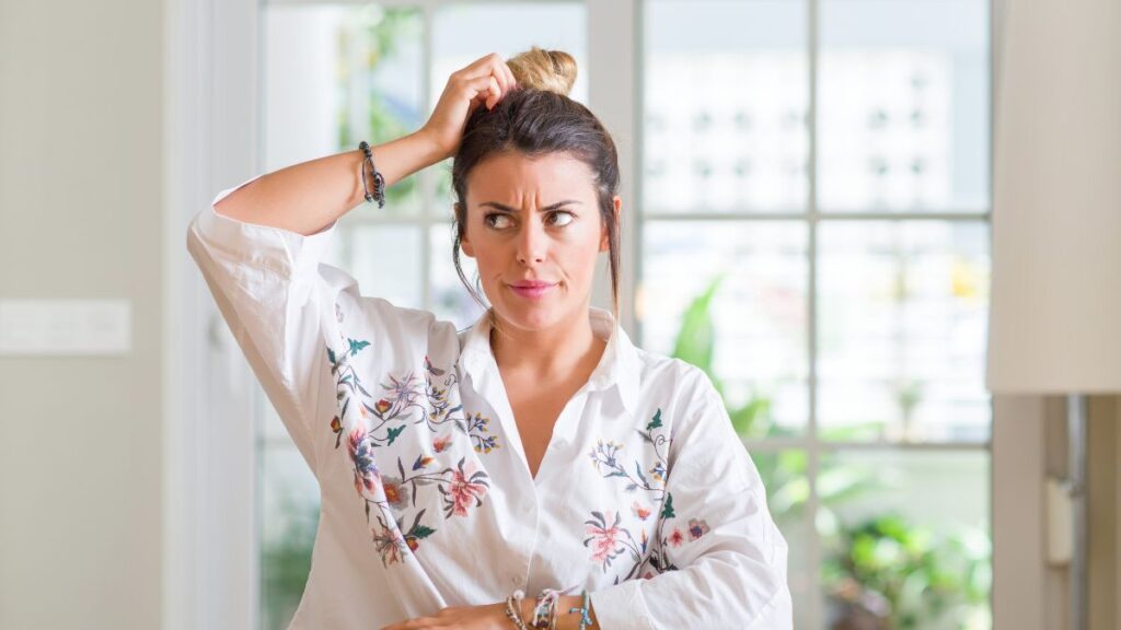 woman looking confused scratching her head