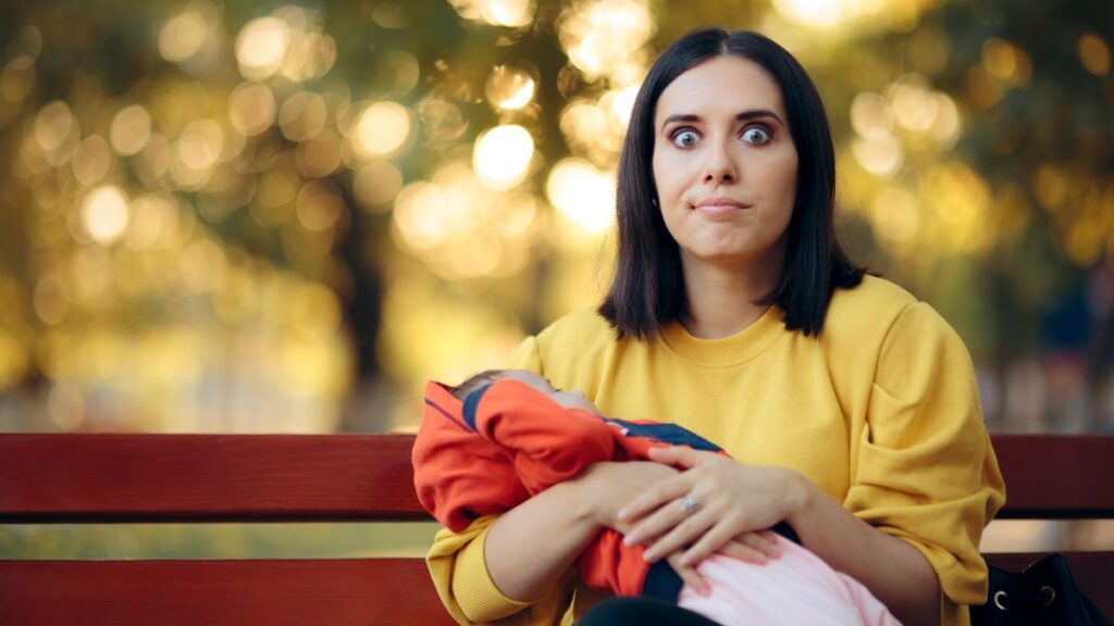 woman looking shocked and confused, holding a baby