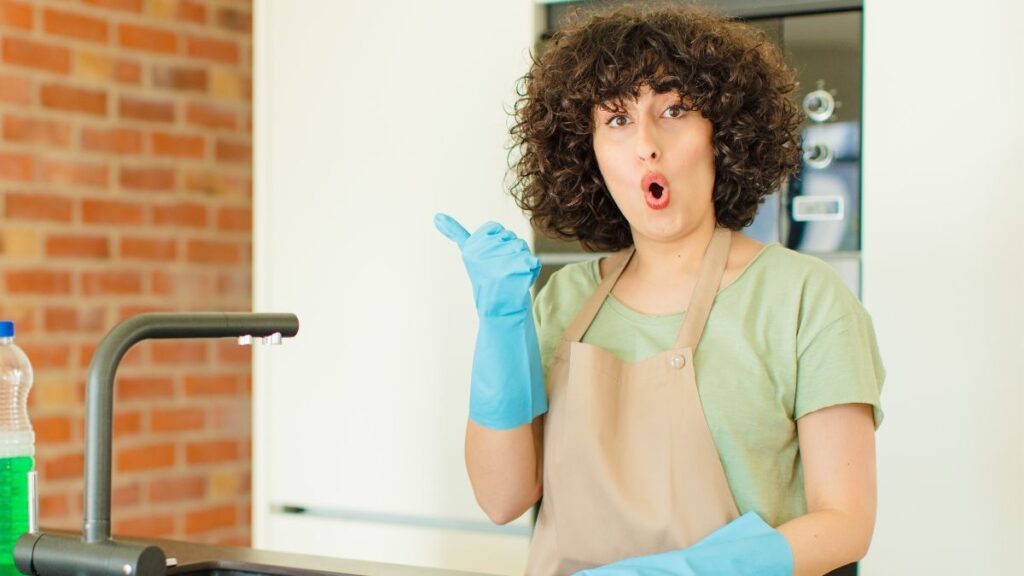 woman looking surprised while cleaning.