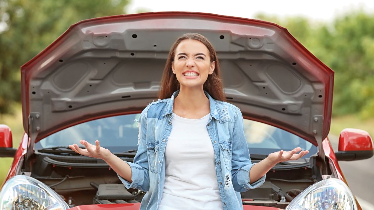 woman looking upset in front of the car