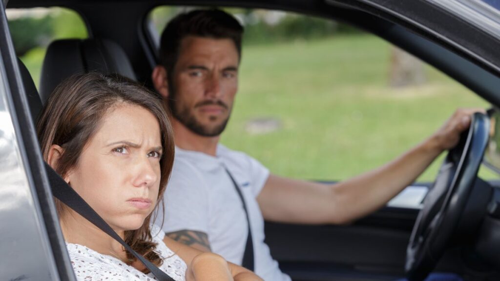 woman pouting in the car, man looking confused