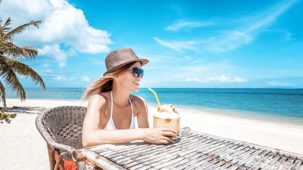 woman sitting at a table on the beach