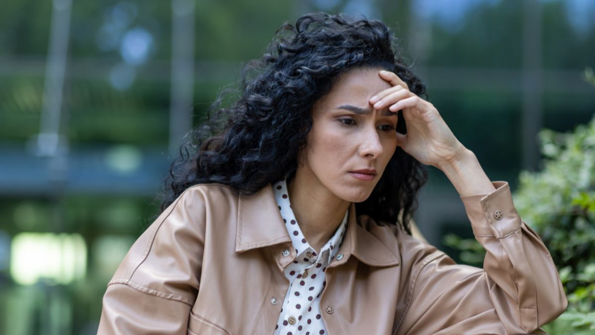 woman sitting upset with hand on head