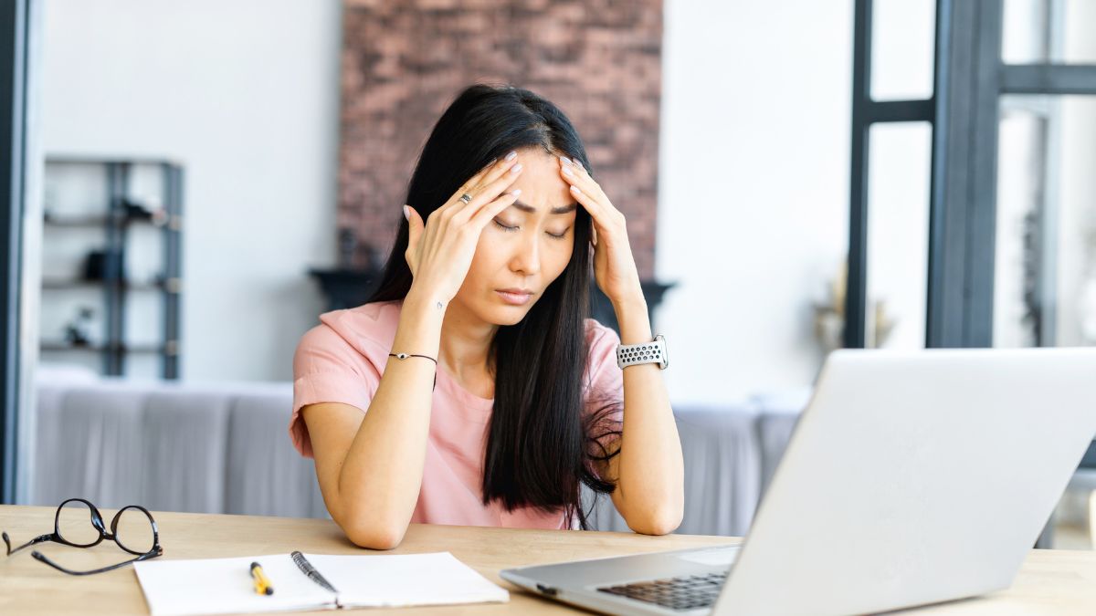 woman stressed with hands on head looking at computer