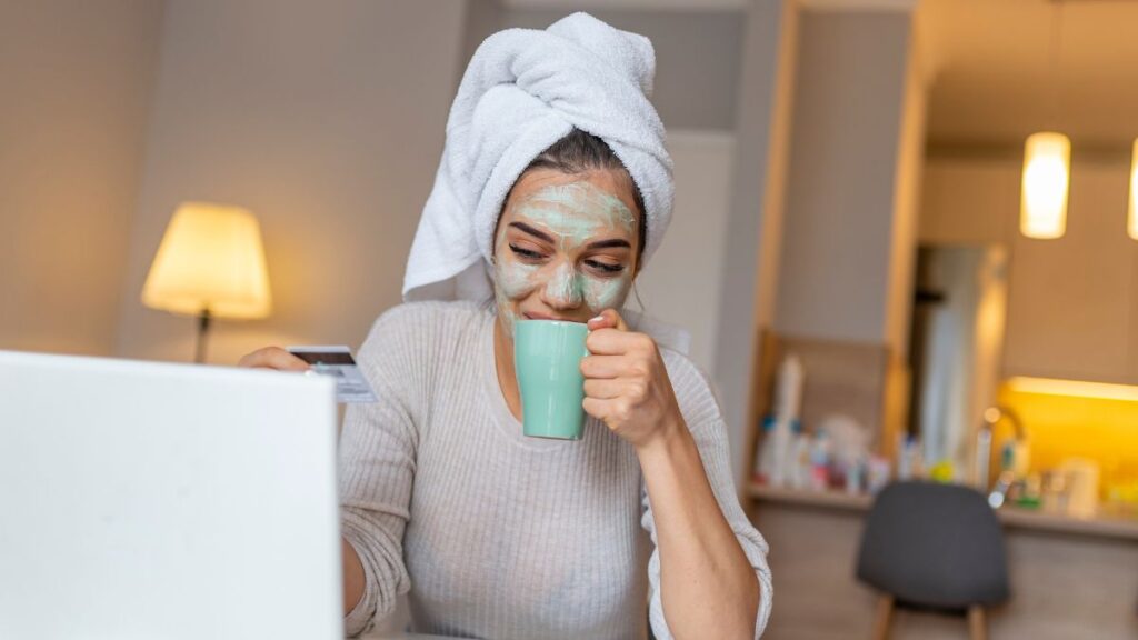 woman with a face mask and coffee working at home