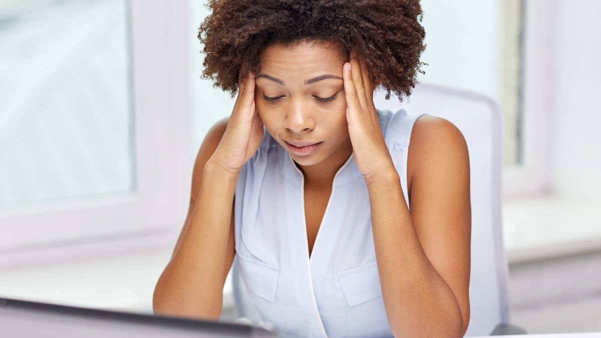 woman with hands on head looking stressed