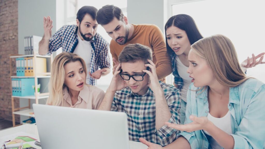 Group of younger adults unhappy around a computer